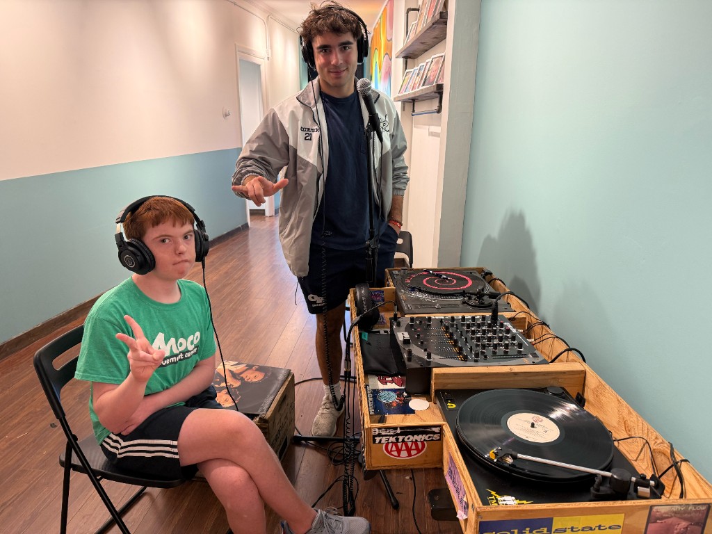 Two friends posing at the Clubhouse DJ booth