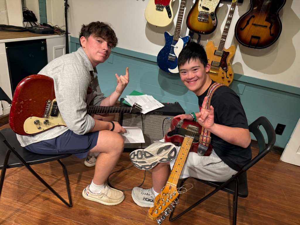 Friends rocking out with electric guitars
