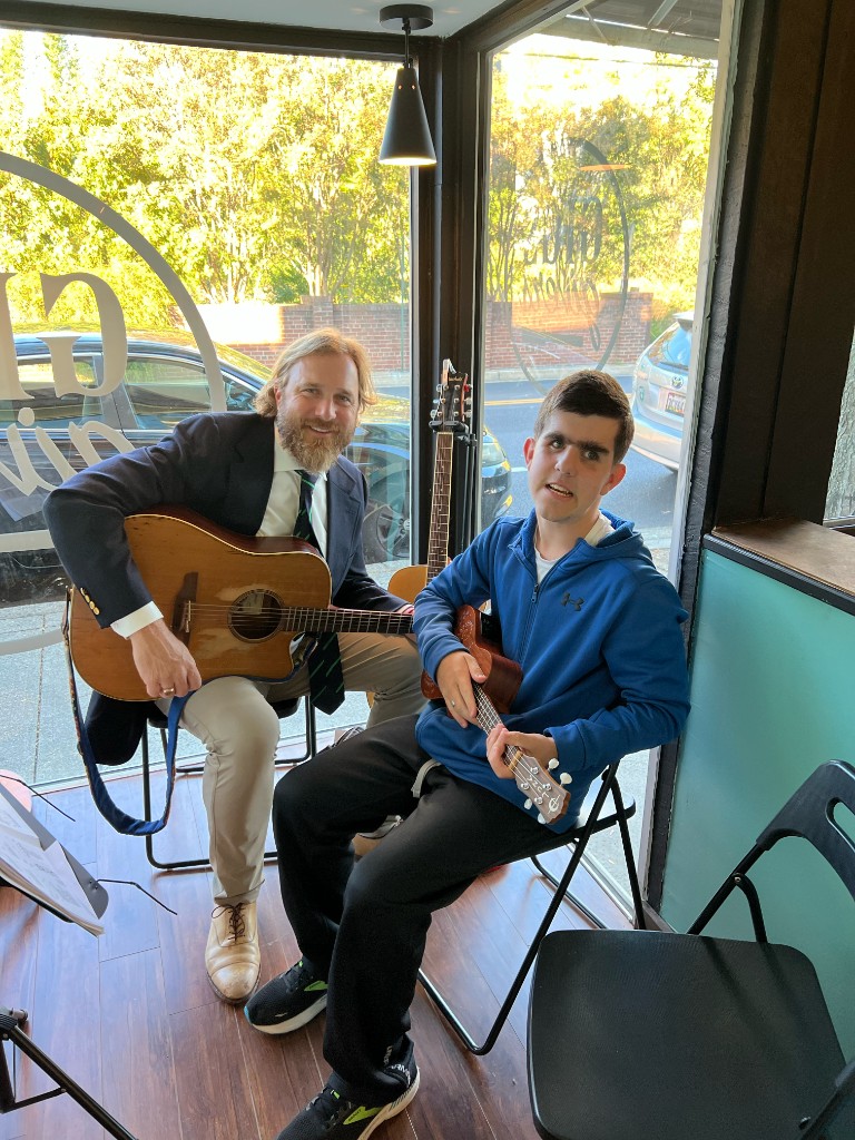 Student with acoustic guitar smiling